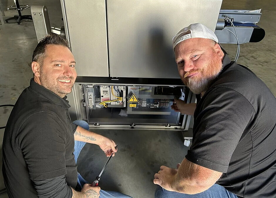 buitendienst service techniekers naast een machine